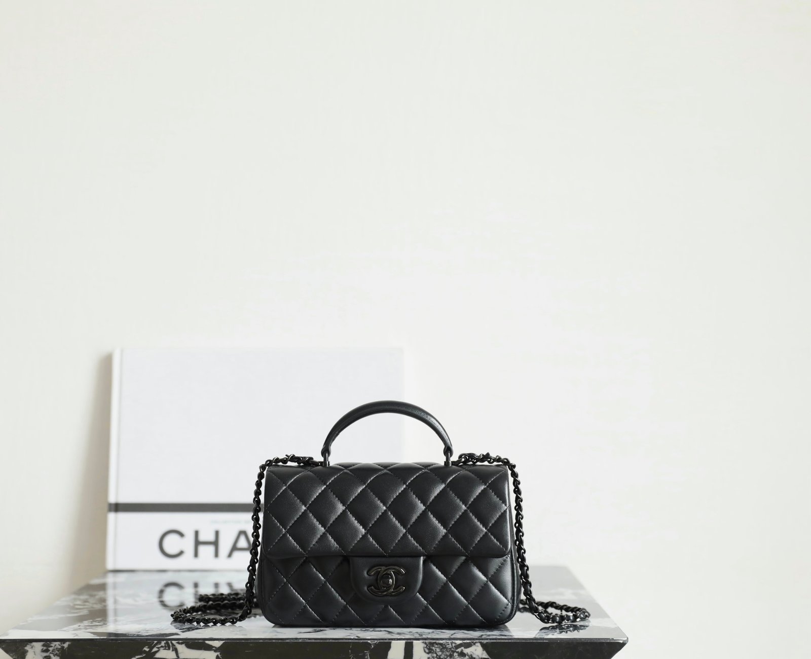 CHANEL Mini Flap Bag with Top Handle – Black Lambskin with All-Black (Gunmetal) Hardware detail image 1 sourced from womanlvbag.com