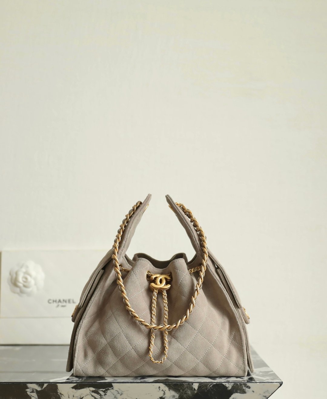 Chanel 25 Small Hobo Bag in chocolate suede with quilted texture, gold-tone chain hardware, and front CC logo.
