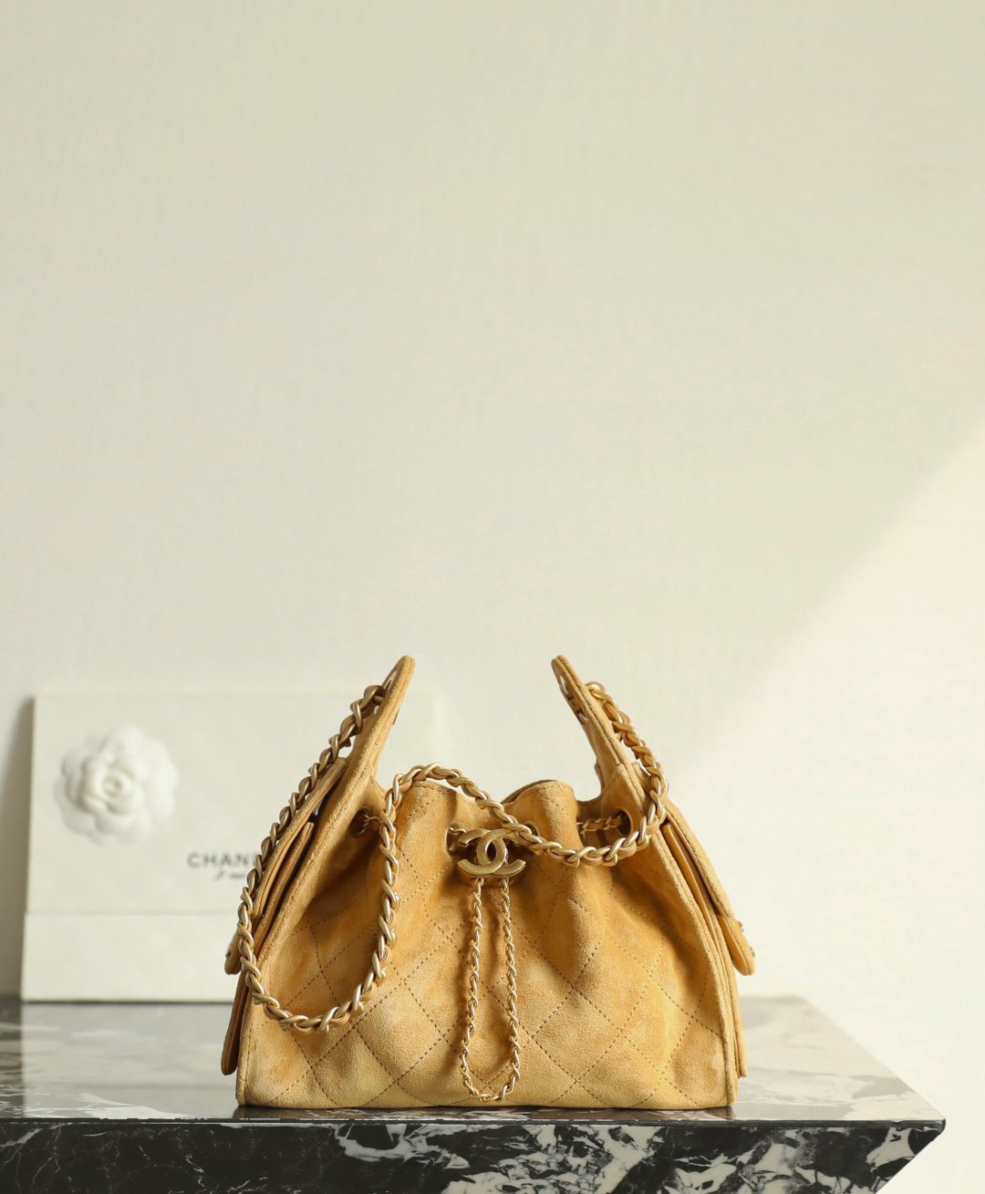 Chanel 25 mini hobo bag side view showing soft suede body, drawstring top, and chain detail
