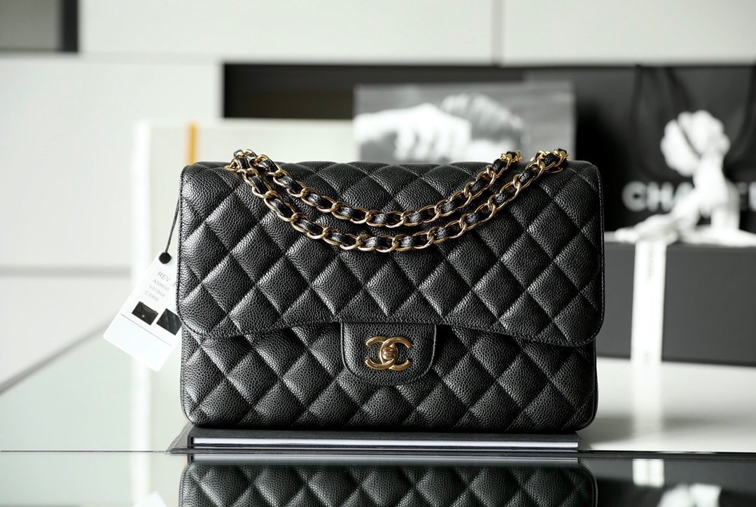 Black Chanel Jumbo Classic Double Flap Bag in caviar leather with light gold CC hardware and chain strap.